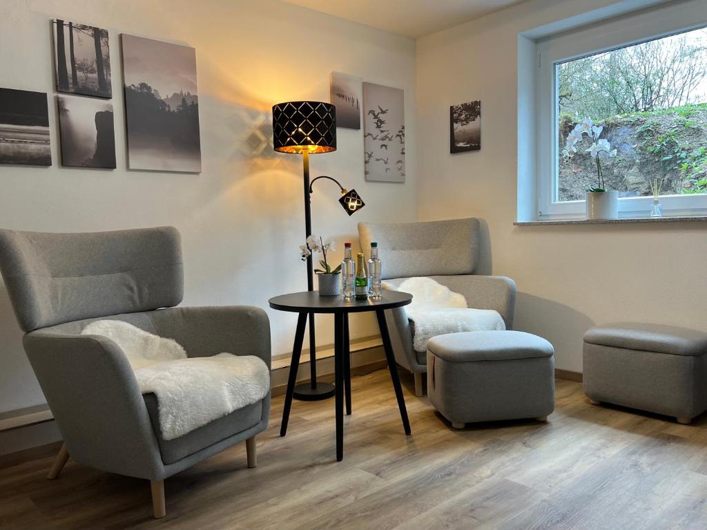 a living room with chairs and a table and a lamp at Top Apartment Zentrum Bad Urach in Bad Urach