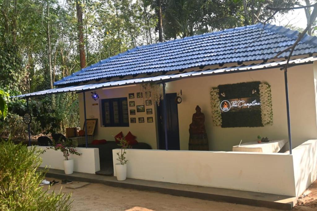 a small house with a blue roof at The Camptime Forest Stay in Suntikoppa