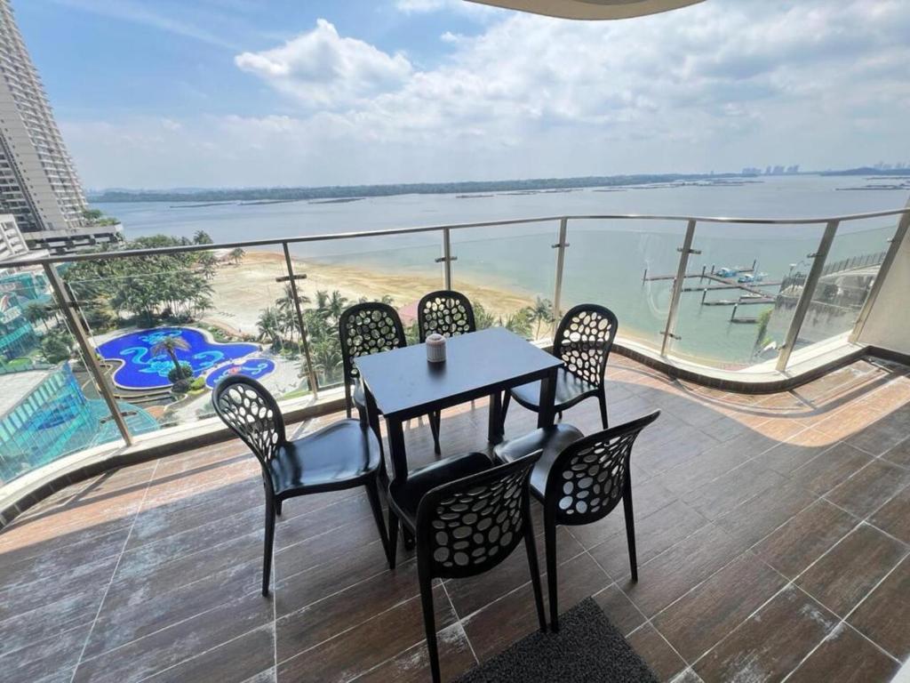 d'une table et de chaises sur un balcon avec vue sur la plage. dans l'établissement Country Garden Danga Bay 2 Rooms 2 Bathrooms by KS, à Johor Bahru