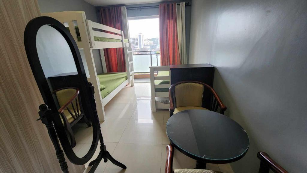 碧瑤的住宿－Conifer Baguio，客房设有镜子、桌子和双层床。