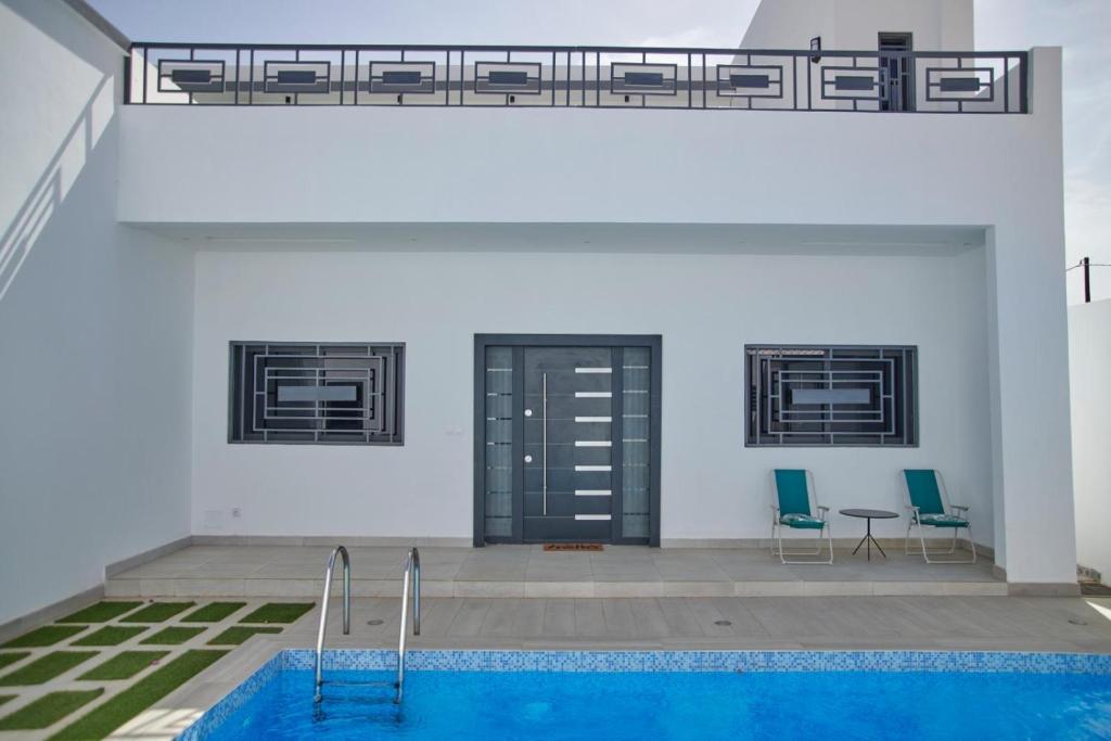 a pool with two chairs and a table in a building at Lovers Villa Somone in Somone