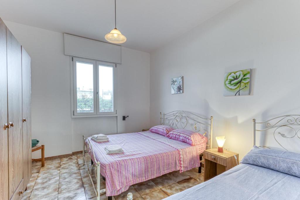 een slaapkamer met 2 bedden en een raam bij Casa Sofia in Torre Pali 