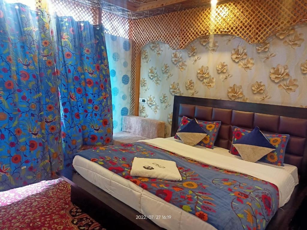 a bedroom with a bed with blue and red curtains at Hotel Kashmir Heaven in Srinagar