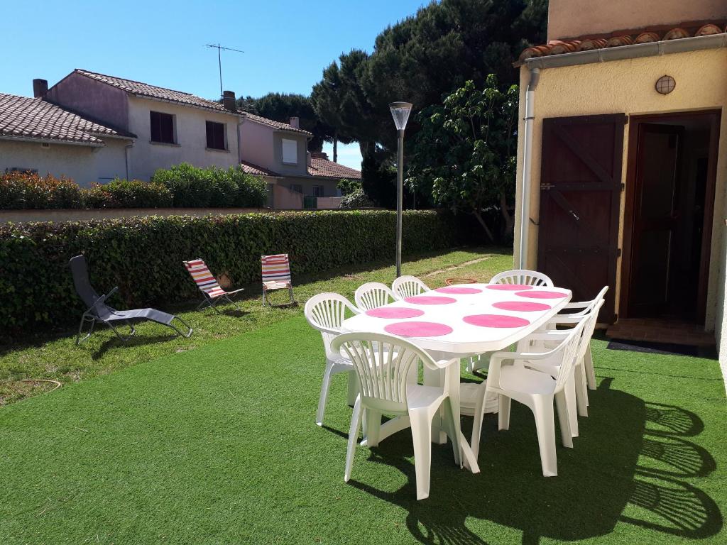 stół i krzesła z różowym i białym stołem w obiekcie Canet en Roussillon belle maison de vacances w mieście Canet-en-Roussillon