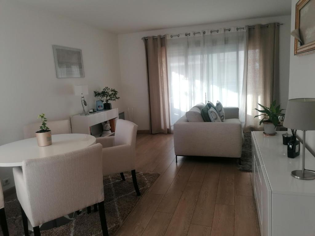 a living room with a couch and a table at Chambre double avec salle de bain commune, a 2 min de la Croisette in Cannes