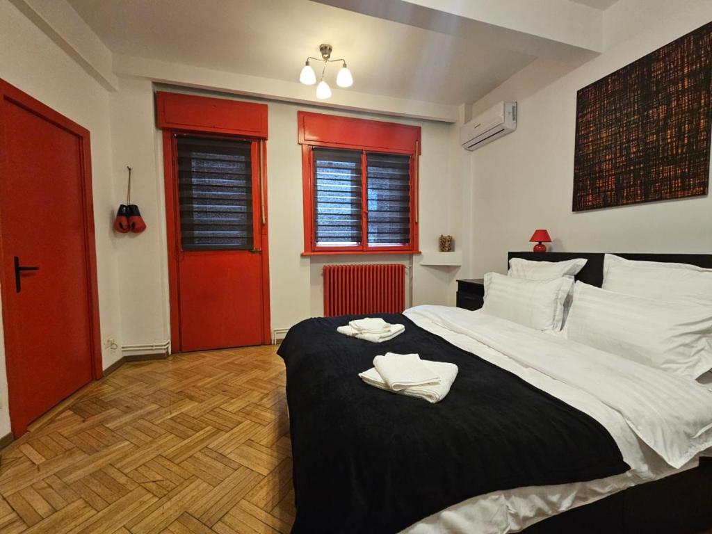 una camera da letto con un grande letto con due asciugamani di Red Velvet Residence a Bucarest