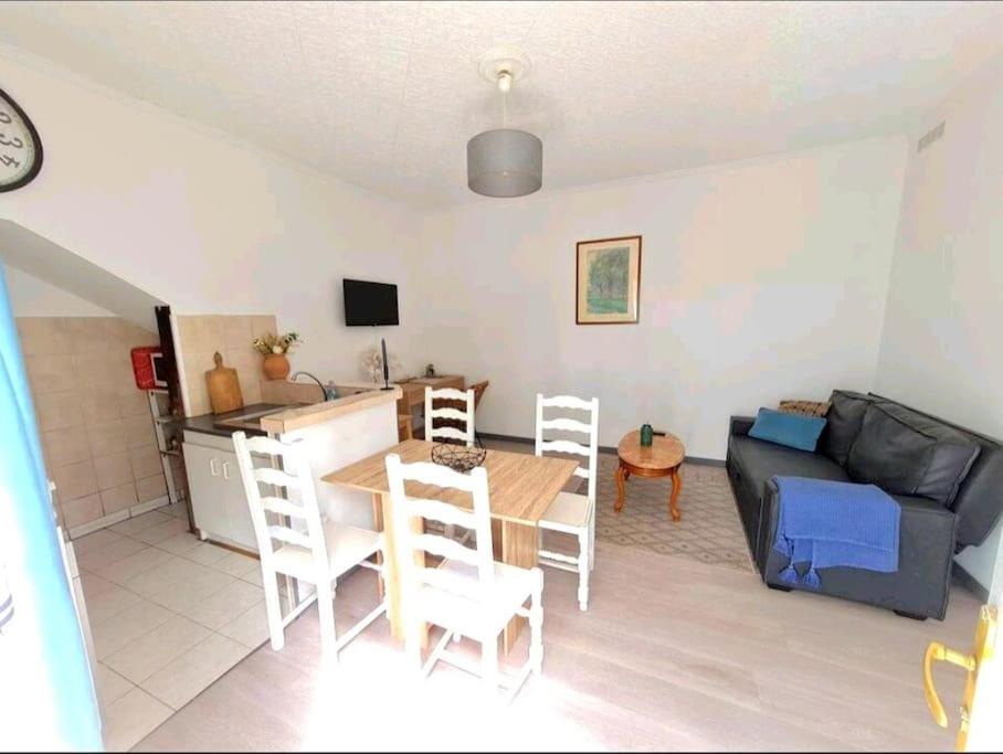 ein Wohnzimmer mit einem Tisch und einem Sofa in der Unterkunft Les alouettes in Nanterre
