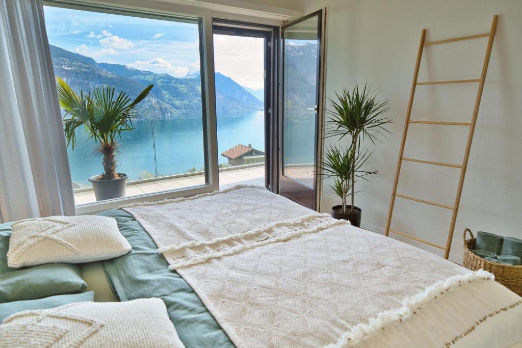 una camera con un letto di fronte a una grande finestra di Dreamview Retreat - Breathtaking Lake Views a Krattigen