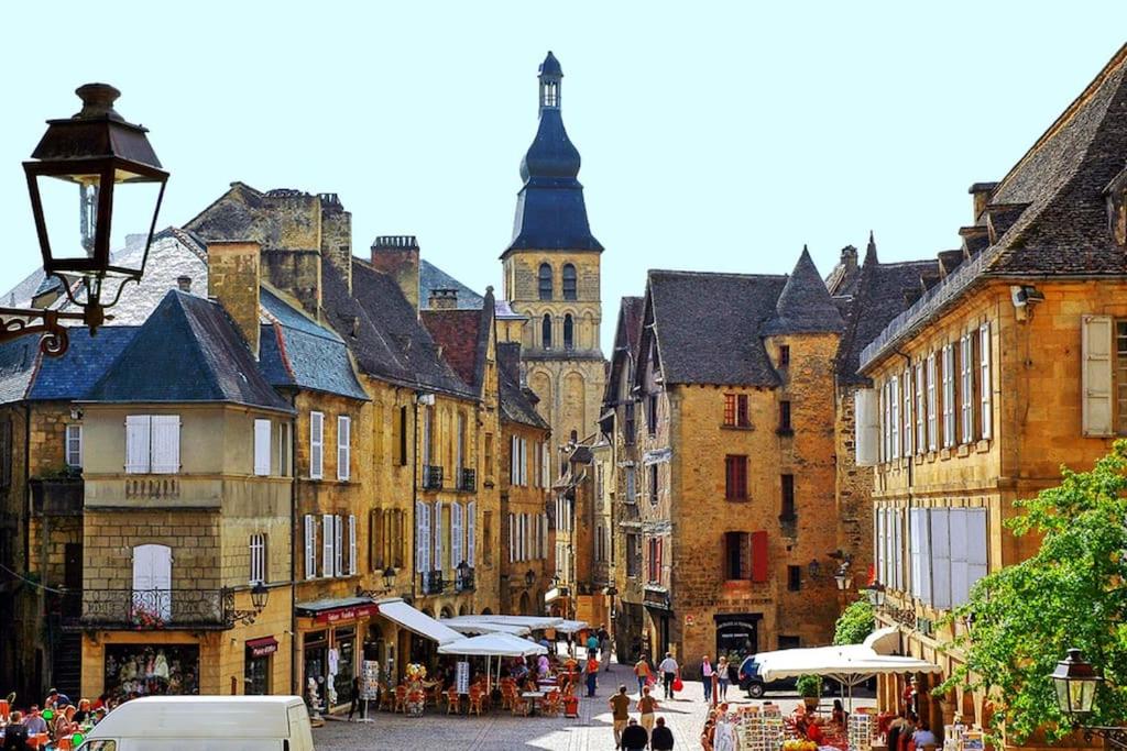 une rue de la ville avec des bâtiments et des personnes marchant dans une rue dans l'établissement Hostelerie du Presidial : 3chbres/3sdb de standing au coeur de la citée de Sarlat, à Sarlat-la-Canéda