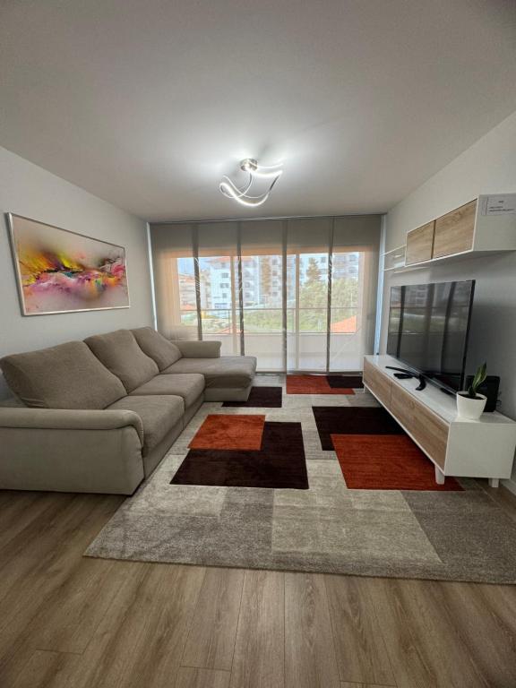 a living room with a couch and a television at Paradise Garajau in Garajau