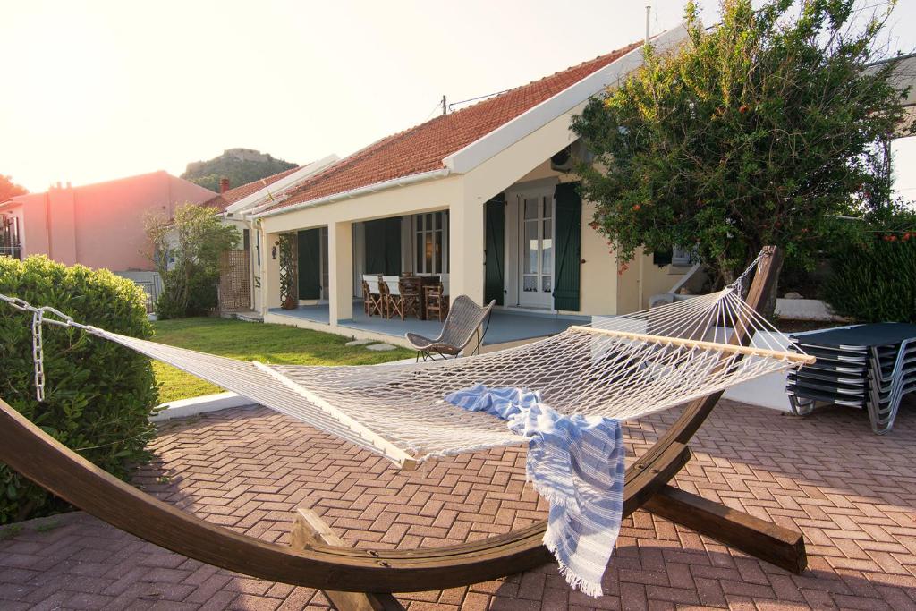 a hammock on a patio in front of a house at Villa Pelagos in Asos
