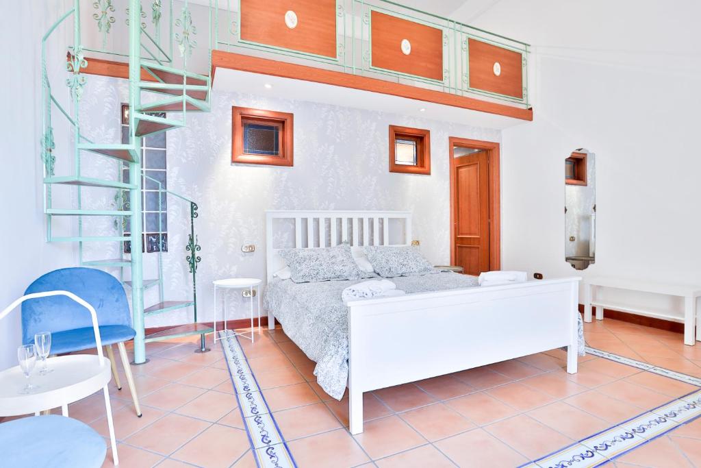 a bedroom with a white bed and a ladder at Chiaia Sea View Gem in Naples