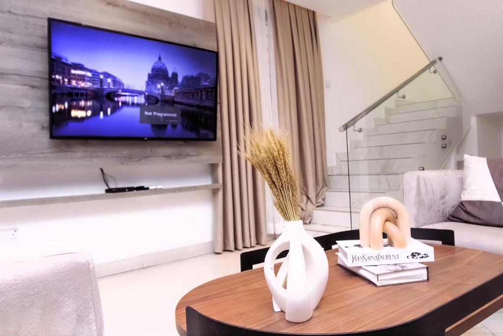 a living room with a table and a tv at Luna Loft in Tema
