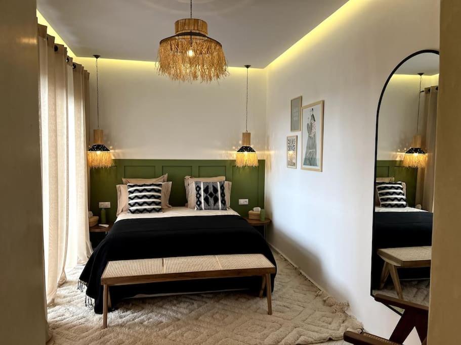 a bedroom with a bed and a large mirror at RIAD LE M neuf et contemporain in Marrakech