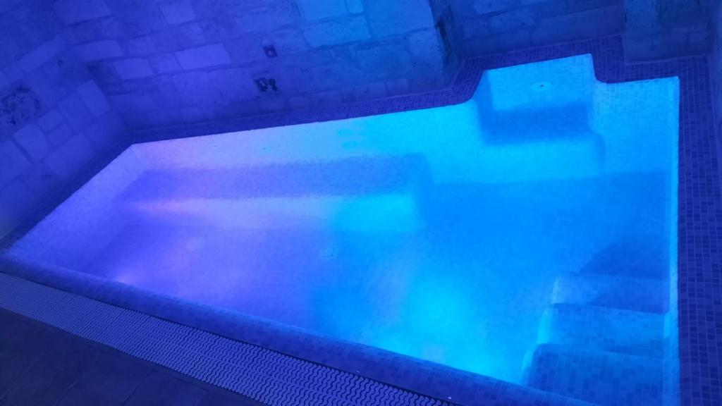 ein großer Pool mit blauem Wasser darin in der Unterkunft Trulli e Puglia Luxury Suite in Alberobello