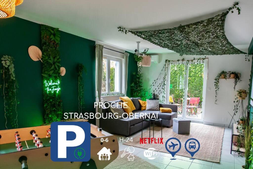 uma sala de estar com paredes verdes e um sofá em Jungle House - Maison em Hurtigheim
