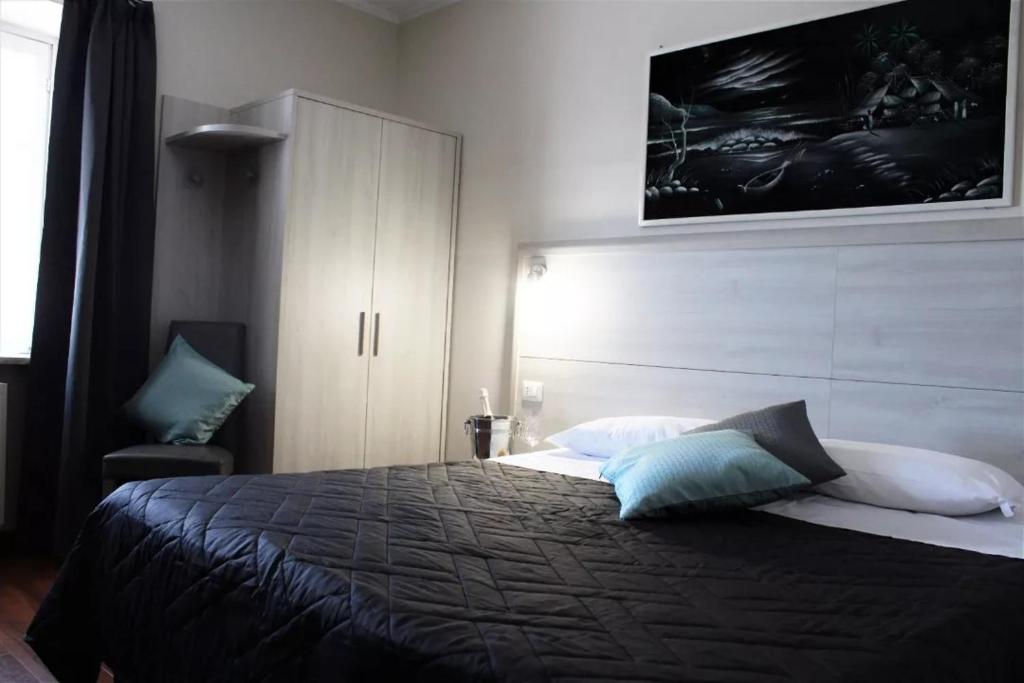 um quarto com uma cama grande e um armário em Nuovo Hotel Giardini em Bra