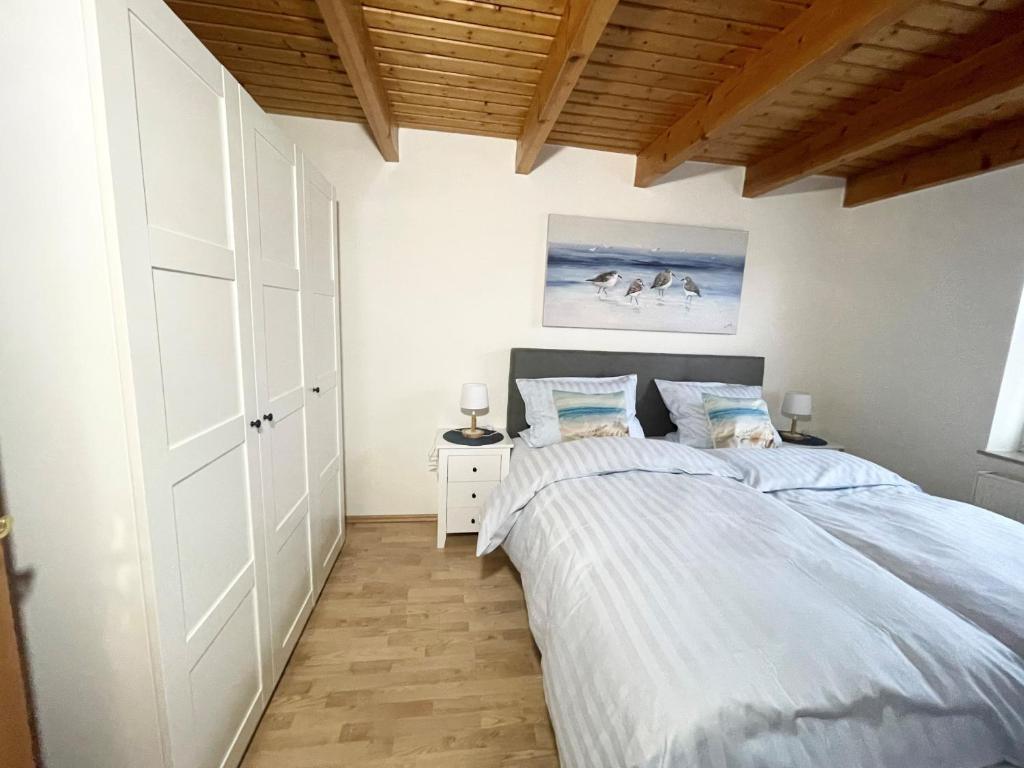ein Schlafzimmer mit einem großen Bett und einer Holzdecke in der Unterkunft Nordseeferien Nessmersiel in Neßmersiel