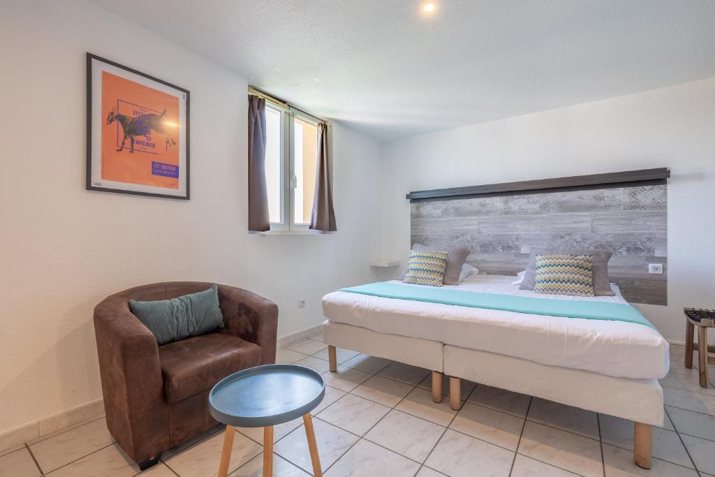 a bedroom with a bed and a chair at Résidence Les Cordeliers in Avignon