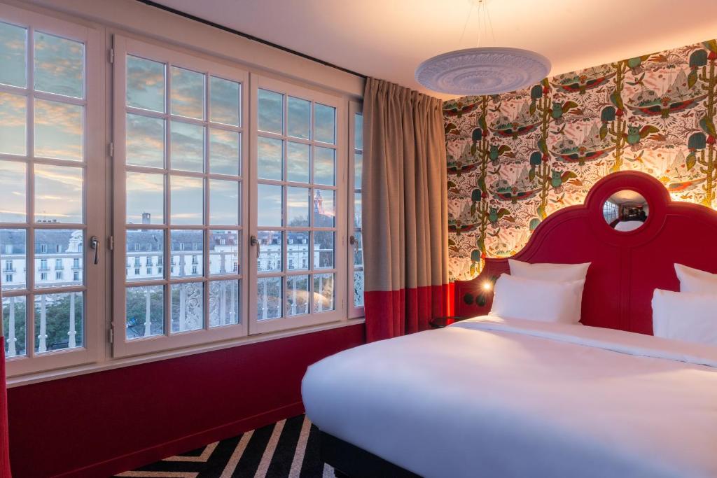 Un dormitorio con una cama grande con una ventana grande. en LABE Hôtel Tours Centre Gare, en Tours
