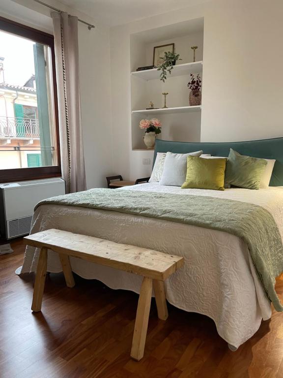 ein Schlafzimmer mit einem großen Bett mit einer Bank darauf in der Unterkunft Enchanting Verona in Verona
