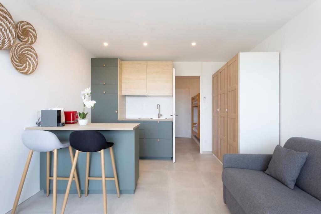 une cuisine et un salon avec un canapé et une table dans l'établissement Chez Olivier - Magnifique studio avec piscine, vue sur la mer et parking, à La Grande Motte