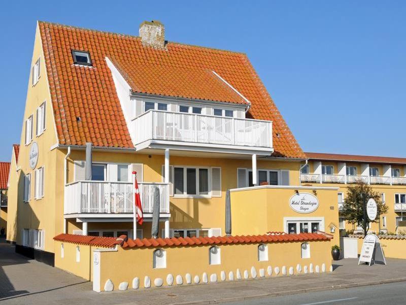 um grande edifício amarelo com um telhado laranja em Plesners Anneks em Skagen