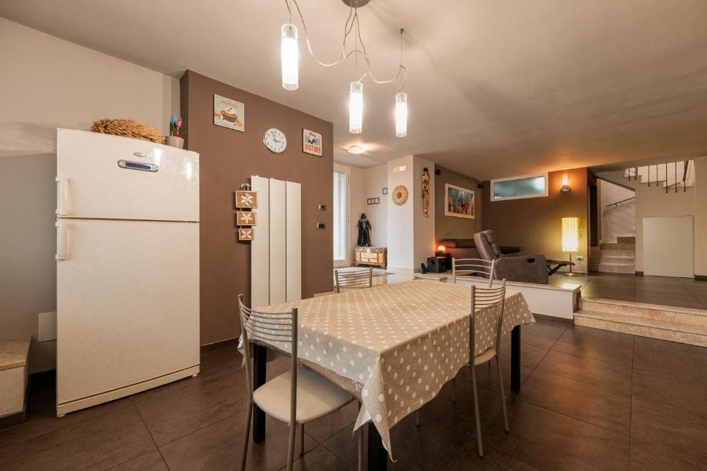 Una cocina y un comedor con una mesa y un refrigerador. en Franciacorta Family Friendly, en Adro