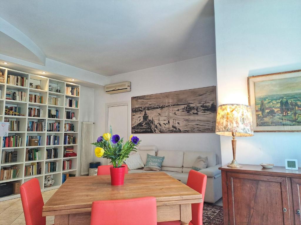 sala de estar con mesa de madera y sillas rojas en Casa Mutti en Asolo