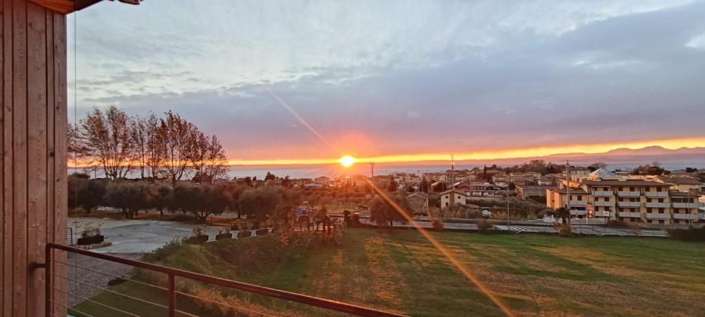 a view of a sunset from a balcony of a city at Apartments Monsurei, Lake view in Bardolino