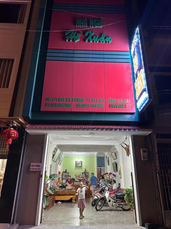 une femme debout à l'entrée d'un restaurant dans l'établissement MoTel HỒ XUÂN, à Pleiku
