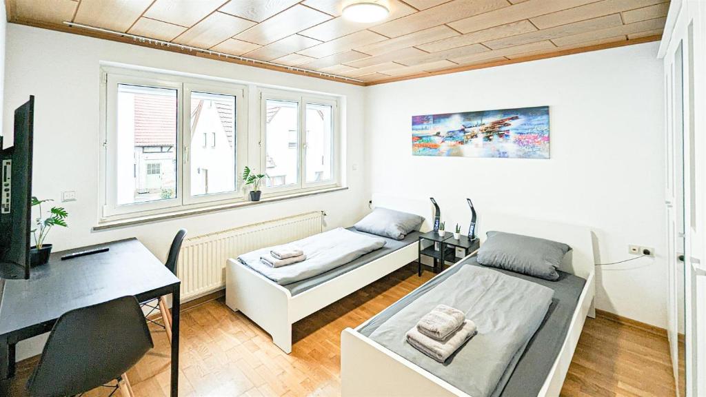 Stuttgart Zuffenhausen Porsche Bosch 1Doppelzimmer Flatshare Apartment في شتوتغارت: غرفة بسريرين ومكتب فيها