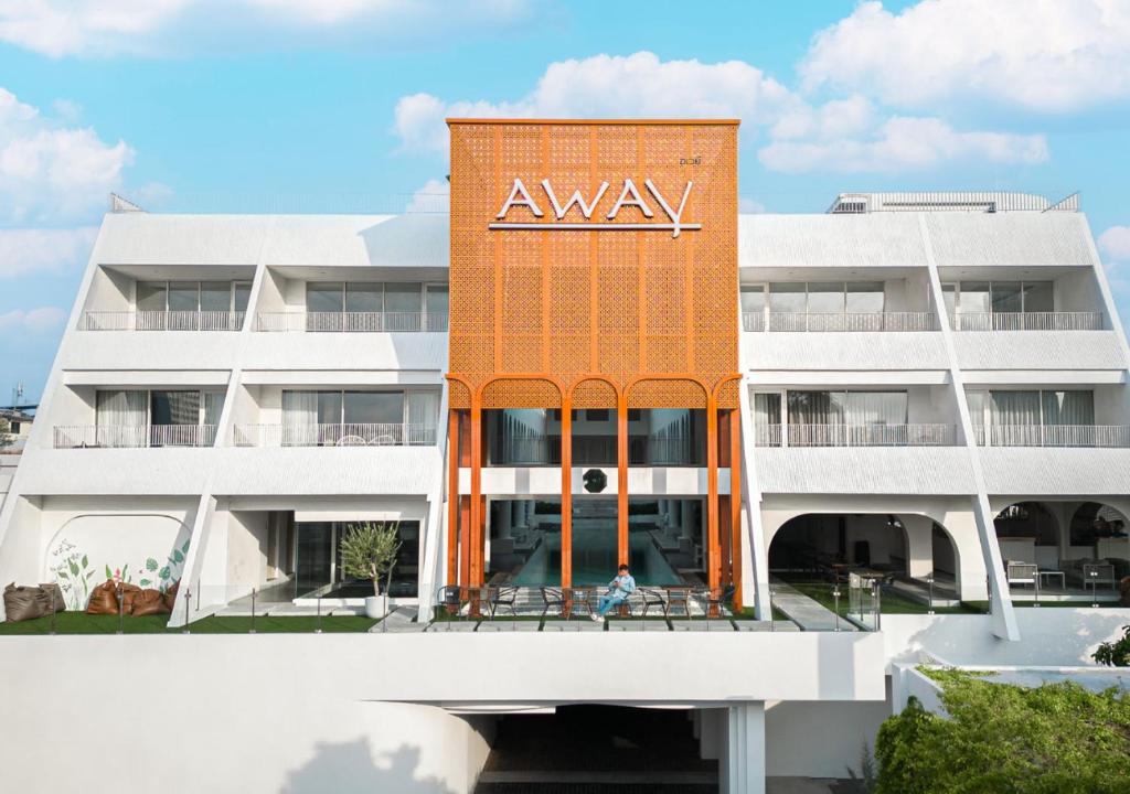 een appartementencomplex met een amway bord erop bij Away Bangkok Riverside Kene in Bangkok