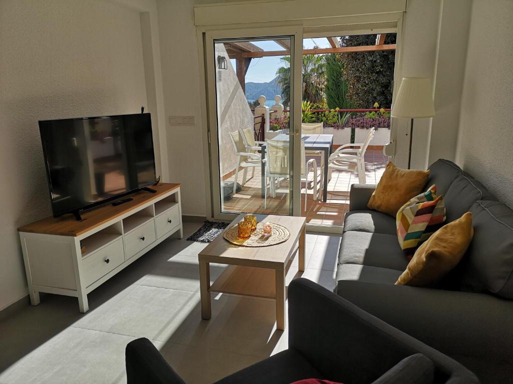 een woonkamer met een bank, een tv en een tafel bij Apartamento de diseño con piscina y garaje in Altea