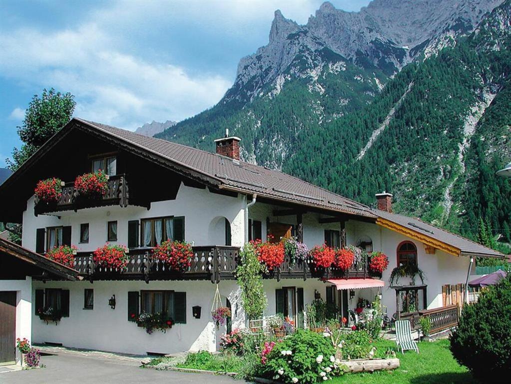 een gebouw met bloemen op de balkons en een berg bij Gästehaus Manfred in Mittenwald