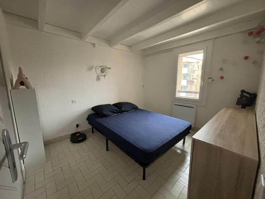 a bedroom with a blue bed in a room at Appartement in Le Boulou