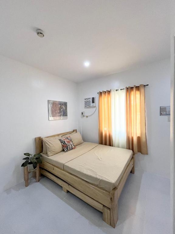 - une chambre blanche avec un lit dans l'établissement Sunnydale Apartelle -Room Accommodation near Calatagan Beach Resorts, à Batangas City