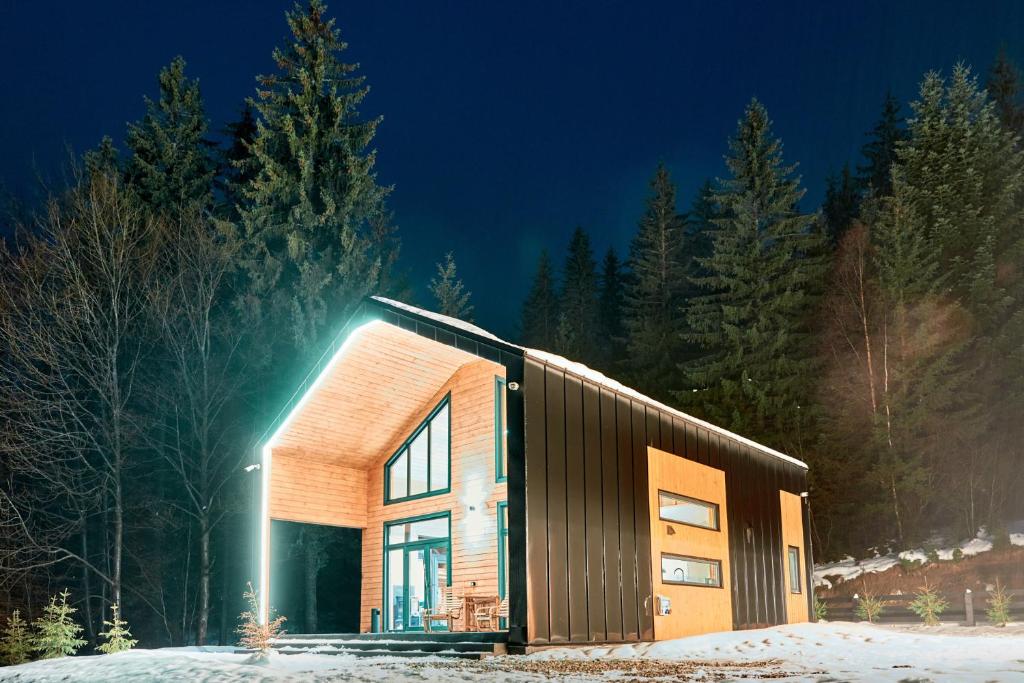 una casa con una fachada de madera en la nieve en Zillya Club en Tatariv