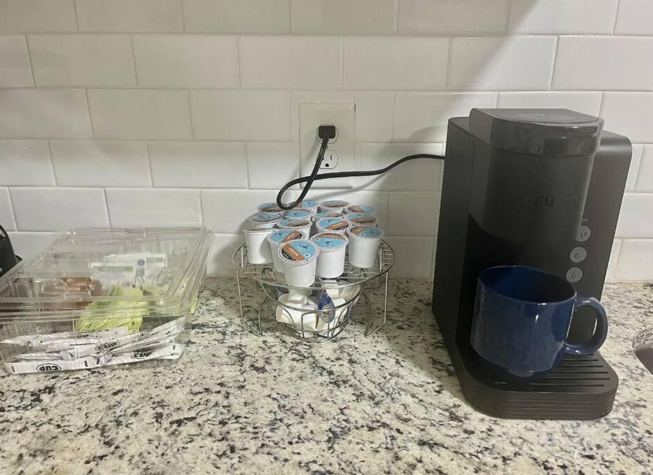 a coffee maker and cups on a counter next to a coffee pot at Memorable and Enjoyable Near all the Action in Athens in Athens