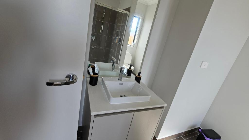 a bathroom with a white sink and a mirror at Private Master Bedroom with Ensuite in Officer in Officer