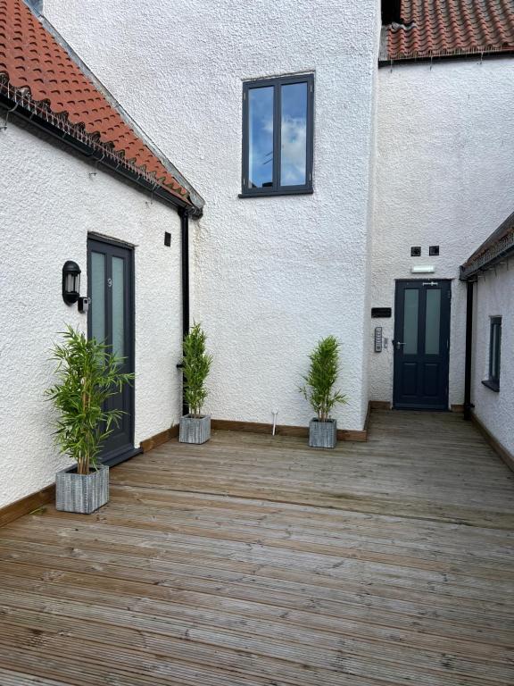 a patio with two potted plants in front of a building at 9 Plants Yard in Worksop