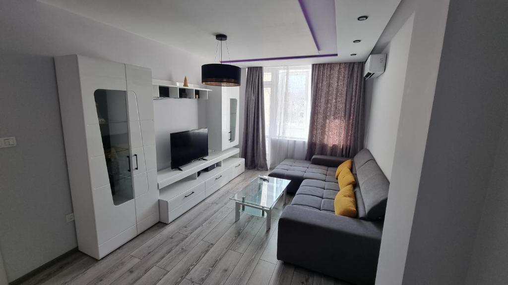 a living room with a couch and a tv at Alexander Home in Gotse Delchev