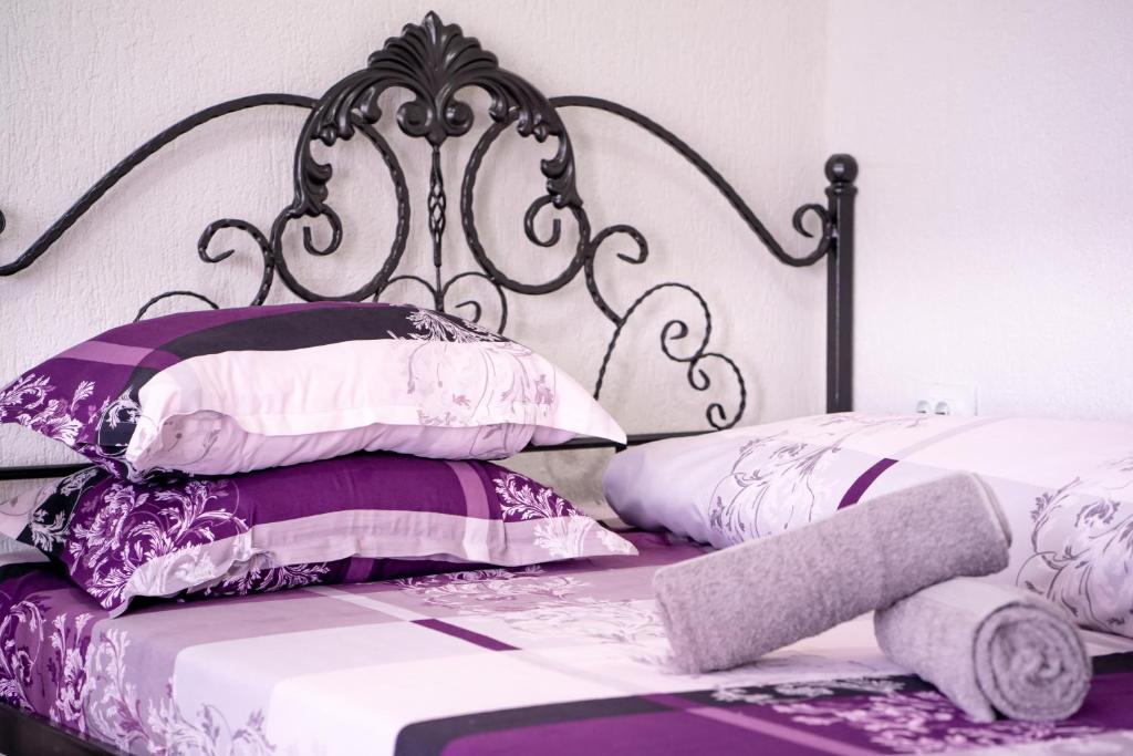 a bed with purple and white pillows and a metal headboard at Complex Route 66 in Vama Veche