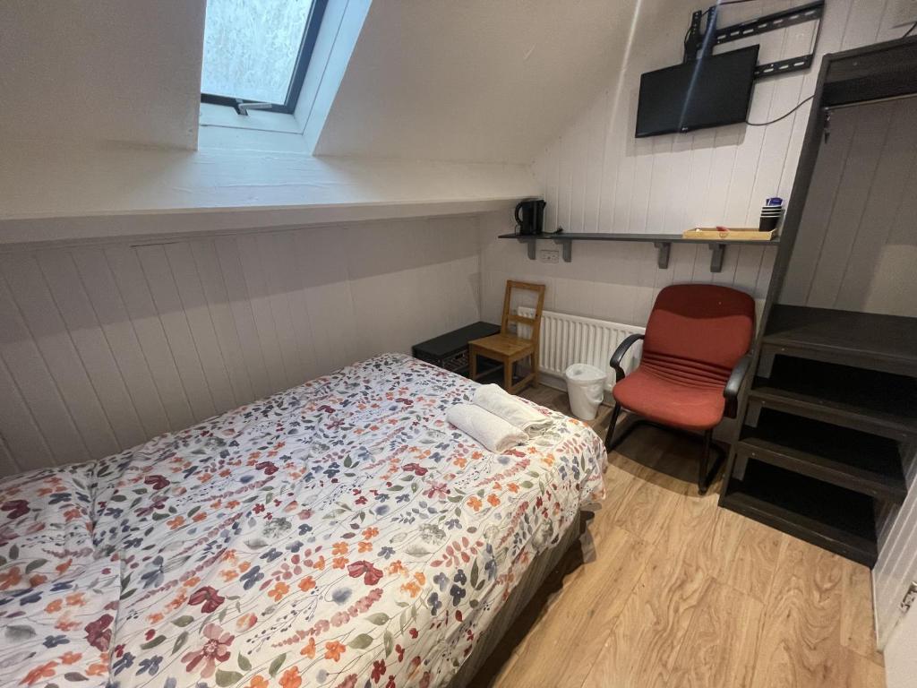 a bedroom with a bed and a red chair at OYO Queens Quarter in Belfast