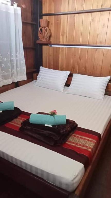 Postel nebo postele na pokoji v ubytování บ้านเรือนไทยมะลิเมืองเก่า