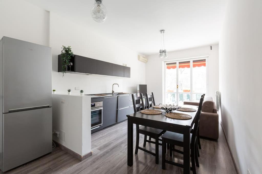 Large Apartment Close to Metro في ميلانو: مطبخ وغرفة طعام مع طاولة وكراسي