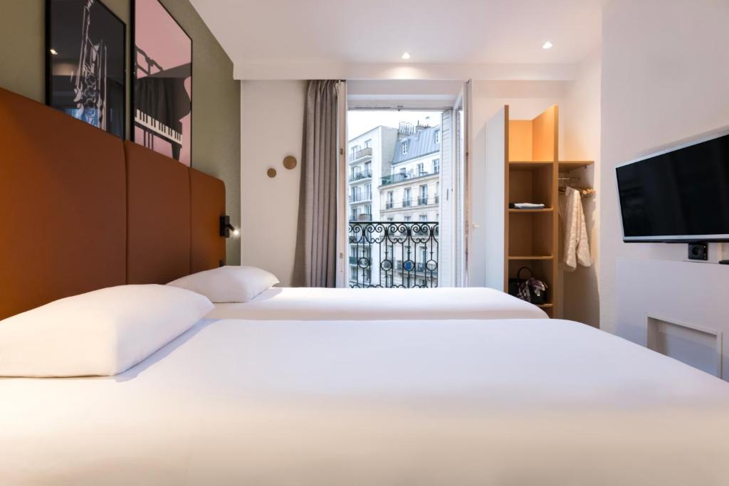ein Schlafzimmer mit einem großen weißen Bett und einem Fenster in der Unterkunft ibis Paris Gare du Nord TGV in Paris