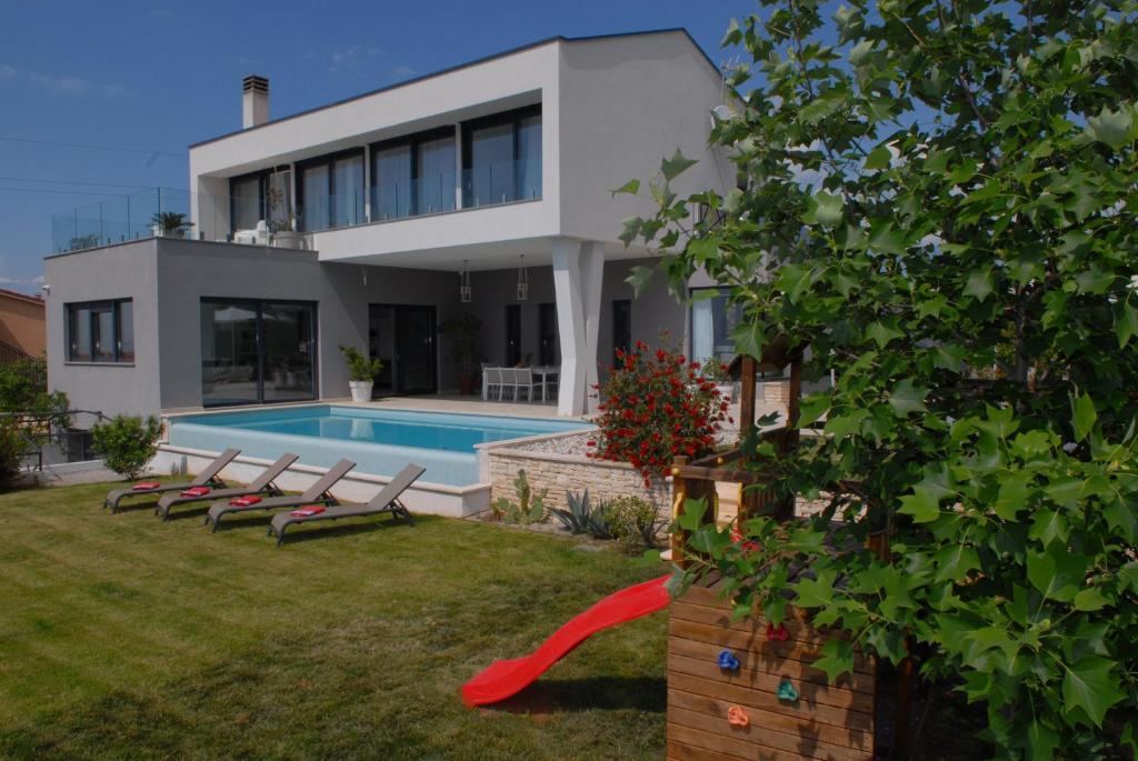 une maison avec une piscine dans l'arrière-cour dans l'établissement Villa Astera near Poreč for 8 people with infinity pool, whirlpool & sauna, à Višnjan