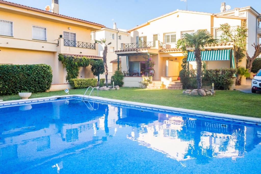 a swimming pool in front of a house at La Calma in Platja  d'Aro