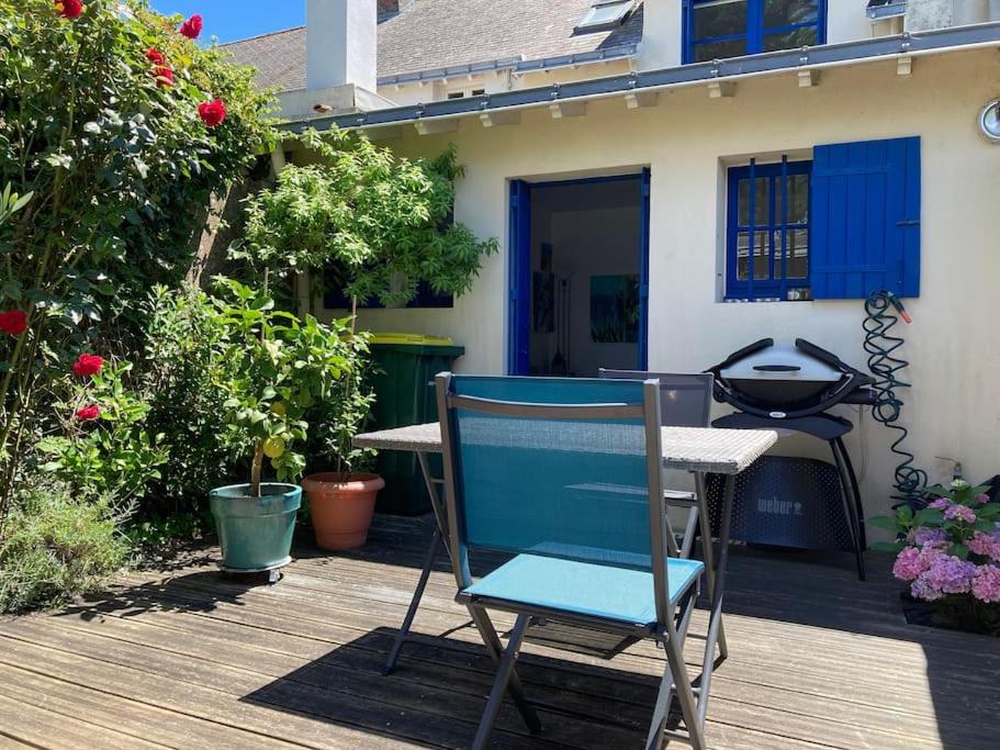 een blauwe stoel naast een tafel op een dek bij Jolie petite maison proche mer in Le Pouliguen